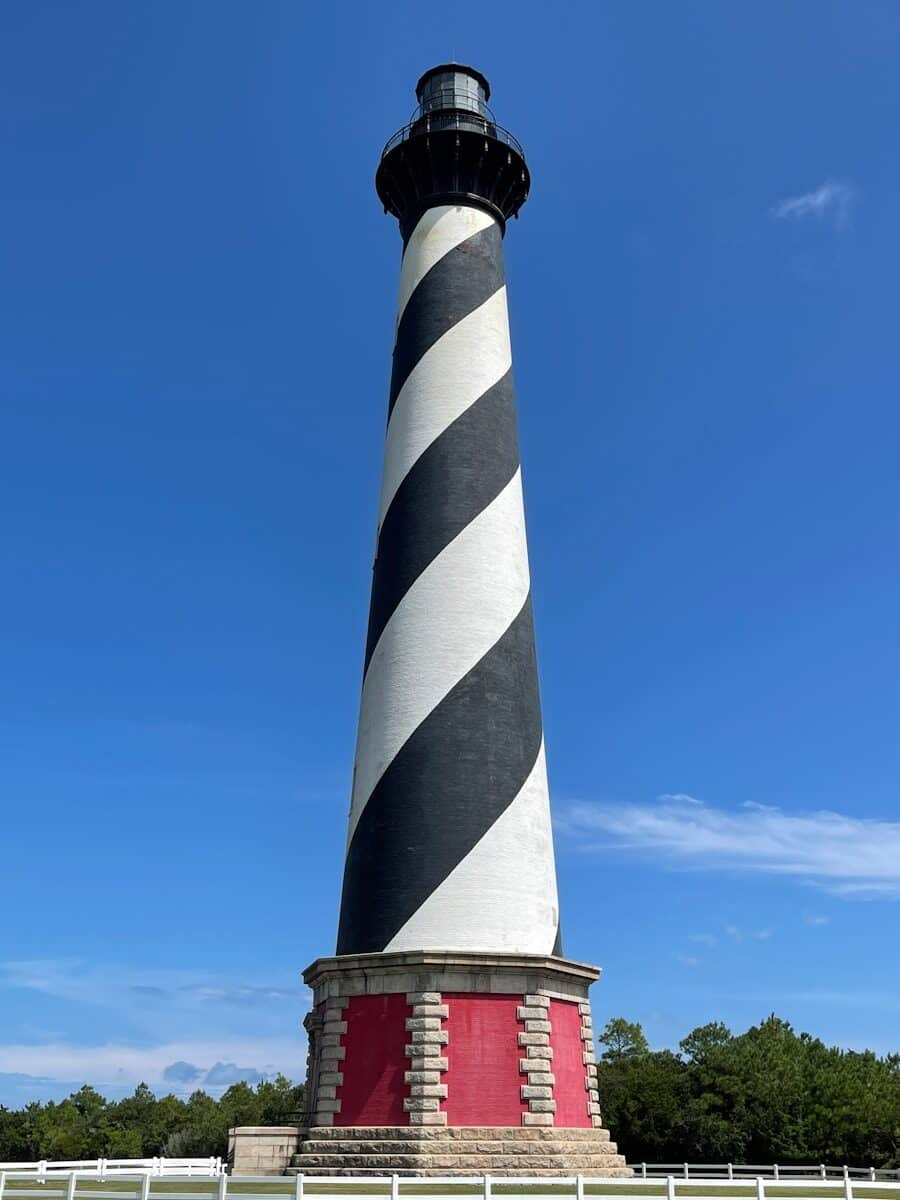 Cape Hatteras Lighthouse on the Outer Banks of North Carolina showing its classic black and white spiral pattern and red brick base