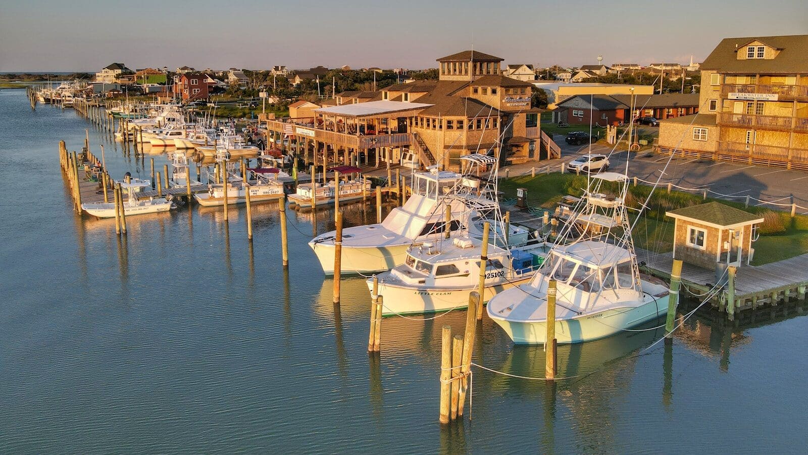 White and blue boats docked on the OBX sound side during daytime