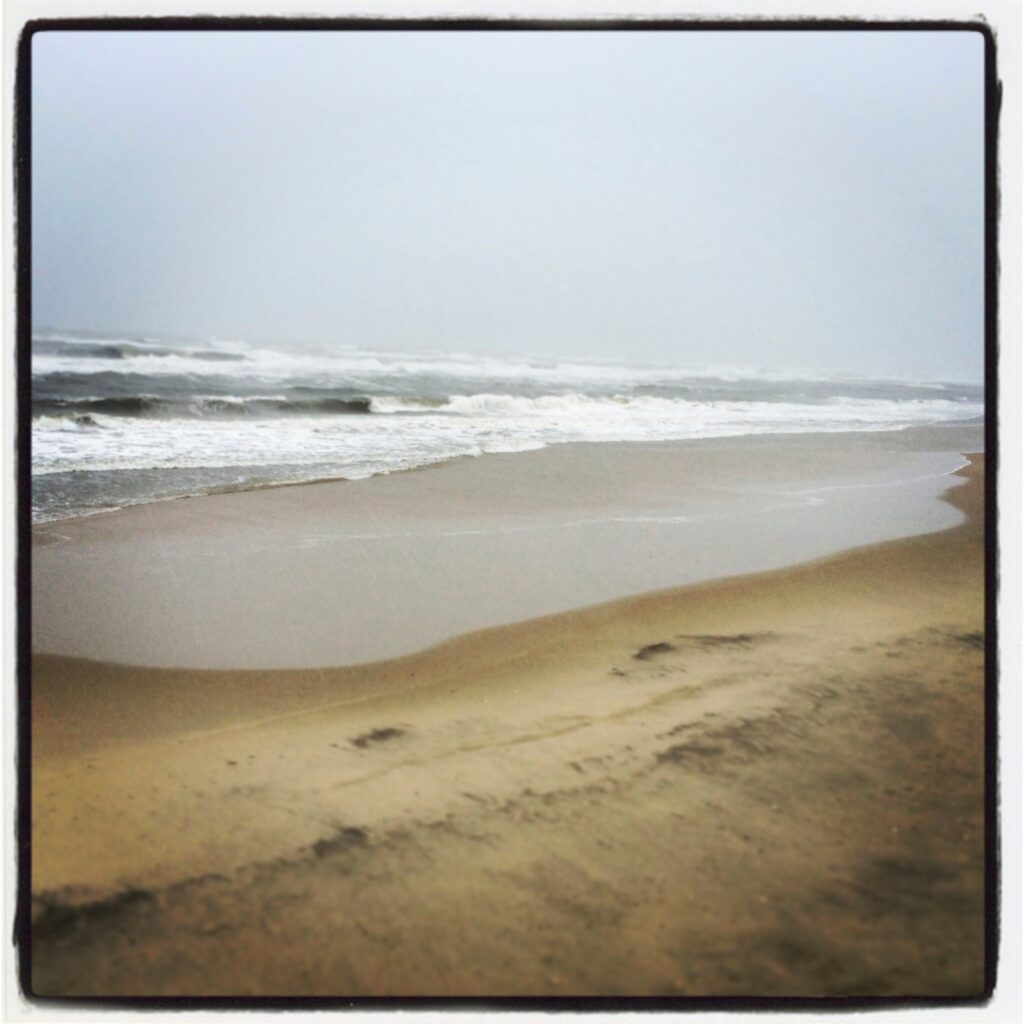 Small waves washing up a wide, empty sand beach at Cape Hatteras National Seashore.